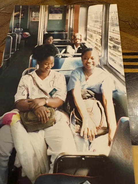Memuna and a friend on the train in nursing scrubs