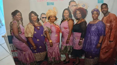 Group celebration in matching pink and purple traditional attire, September 2016