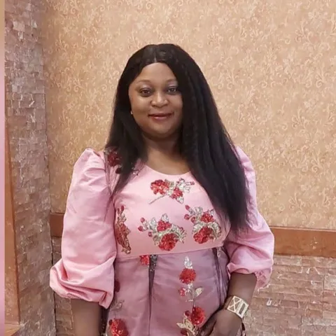 Portrait of Memuna in a pink floral embroidered dress
