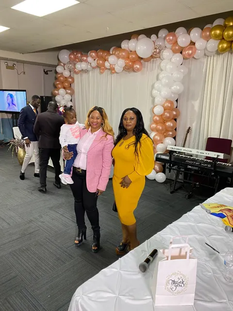Memuna in a pink blazer with a friend in yellow at a celebration