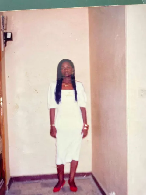 Memuna in a white dress and red shoes