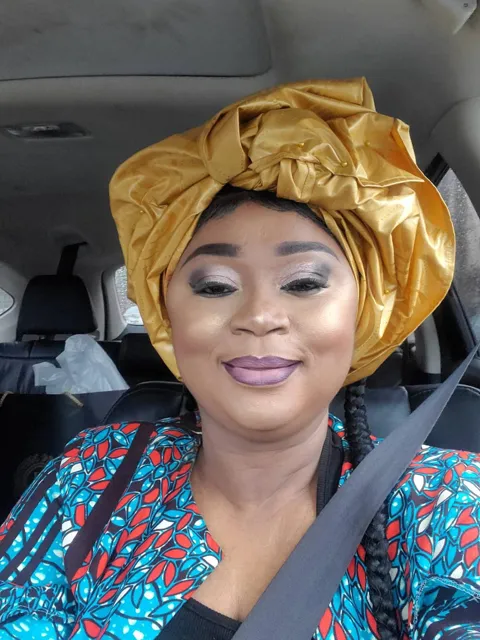 Memuna in a gold headwrap and patterned blouse
