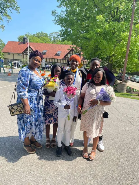 Family at a graduation, holding bouquets of flowers