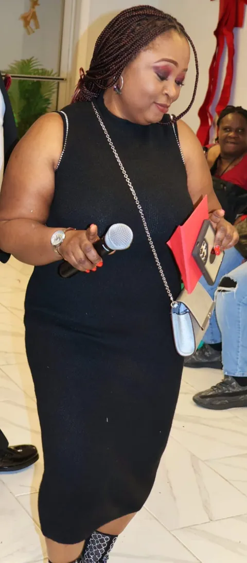 Memuna in a black dress at a celebration