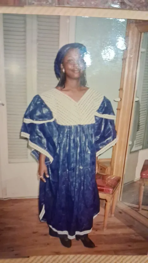 Memuna in a traditional blue and gold gown