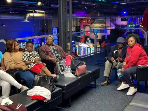 Family seated together at an arcade lounge